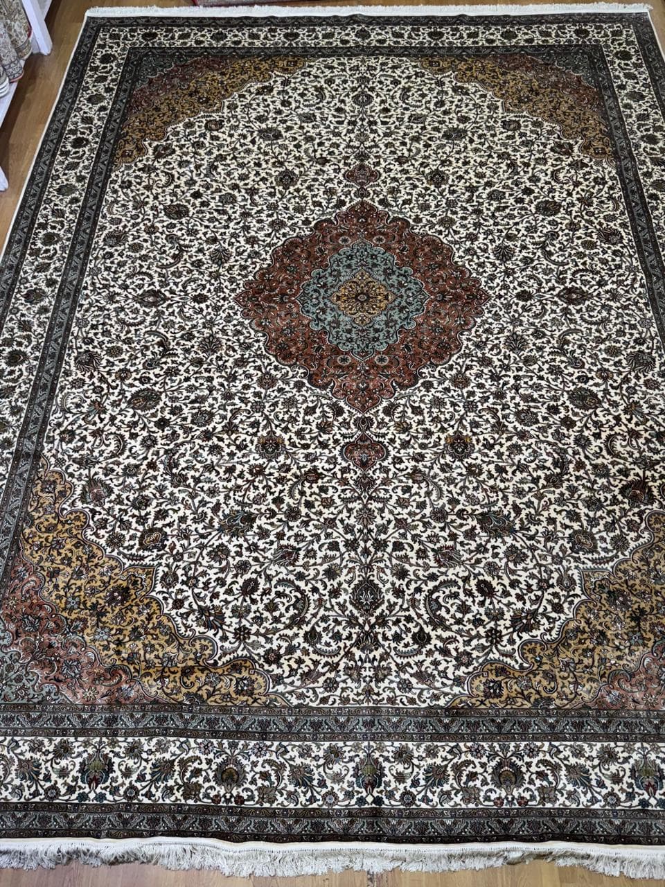 Ivory medallion silk rug with rust and gold corners