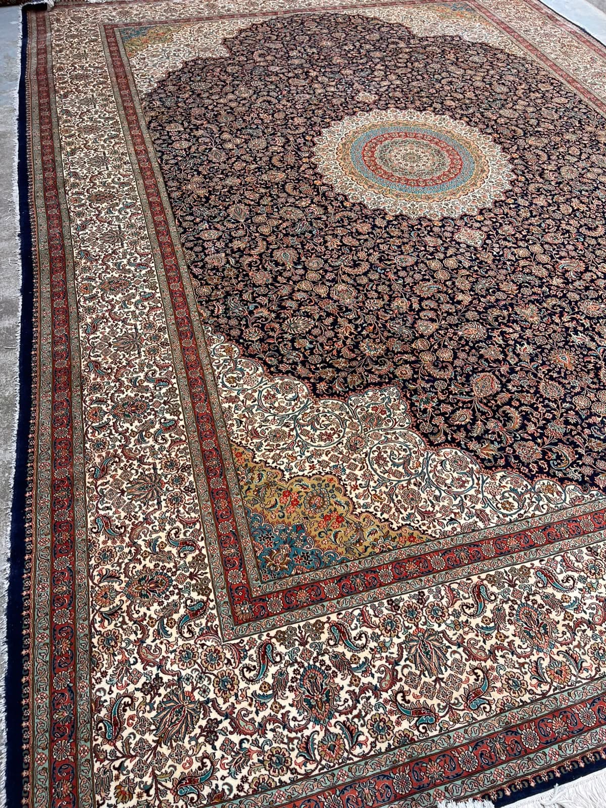 Navy rosette-medallion silk rug (angled view)